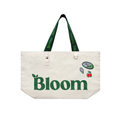 Beige tote bag with 'Bloom' branding on a light green background with decorative elements.
